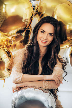 Portrait of beautiful woman air golden and silver ballsの写真素材