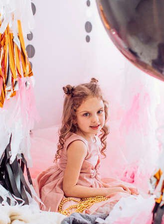 Beautiful little girl celebrating birthday party with big bouncy balls. Family celebration of the childの写真素材