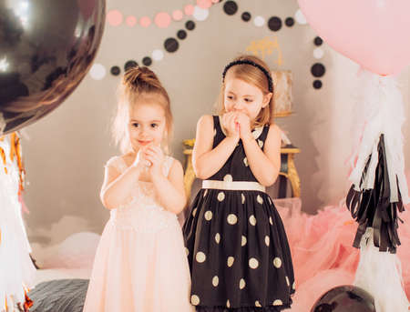 Beautiful little girls celebrating birthday party with big bouncy balls. Family celebration of the childの写真素材