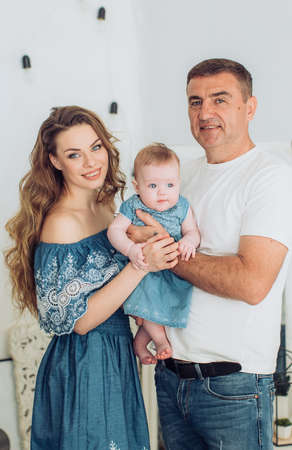Young happy mother and father with baby girl