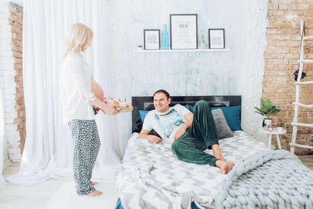 Beautiful pregnant woman with her husband in her bedroom