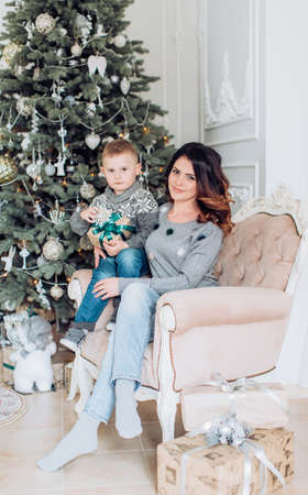 Happy boy with mather near Christmas treeの写真素材