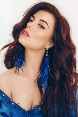 Portrait of beautiful young brunette woman with makeup in fashion blue clothesの写真素材