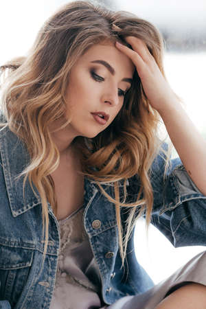 Portrait of beautiful young woman with makeup in fashion blue clothes