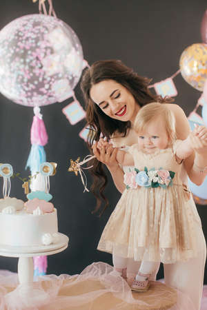 Photo of a beautiful young woman with little daughter celebrate her birthday