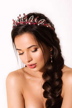 Portrait of a beautiful young brunette woman with makeup and a beautiful hair-do by the decorated stylish bijouterieの写真素材