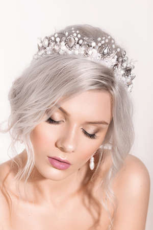 Portrait of a beautiful young blonde woman with makeup and a beautiful hair-do by the decorated stylish bijouterieの写真素材