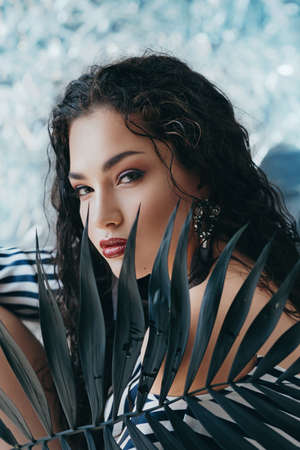 Portrait of beautiful young brunette woman with makeup in fashion clothes