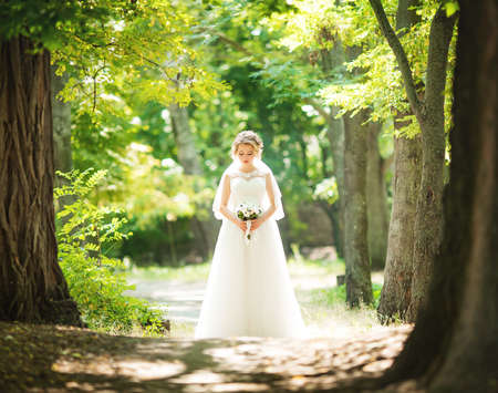 Beautiful bride in white dress in the gardenの写真素材
