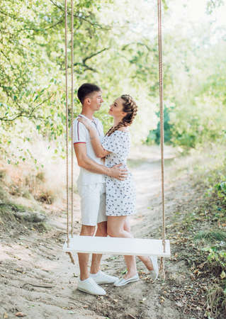 Young couple on park lawn on swingsの写真素材