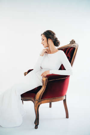 Beautiful brunette girl with stylish make-up in white dressの写真素材