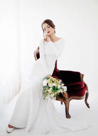 Beautiful brunette girl with stylish make-up in white dressの写真素材