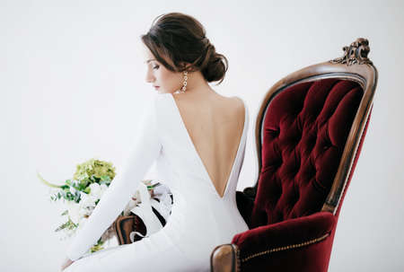 Beautiful brunette girl with stylish make-up in white dressの写真素材