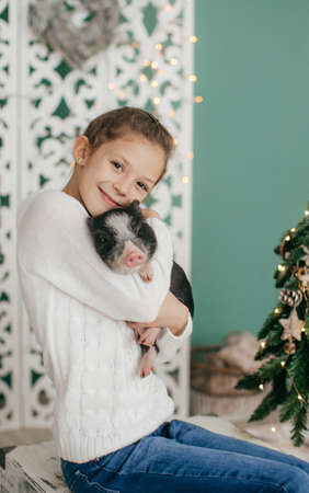 Beautiful baby girl near black vietnamese piglet. Concept of the Chinese New Year 2019 of the Pigの写真素材