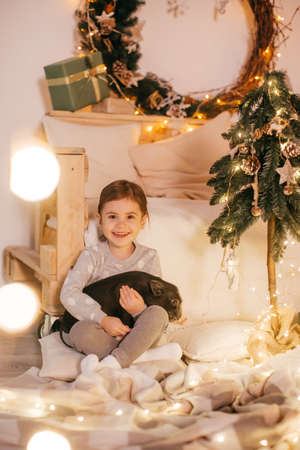 Beautiful baby girl near black vietnamese piglet. Concept of the Chinese New Year 2019 of the Pigの写真素材