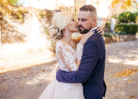 Bride and Groom at Wedding Day walking Outdoors on autumn nature. Bridal couple, Happy Newlywed woman and man embracing in autumn park. Loving wedding couple outdoor.の写真素材