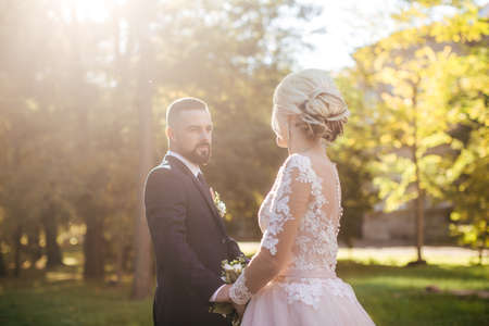 Bride and Groom at Wedding Day walking Outdoors on autumn nature. Bridal couple, Happy Newlywed woman and man embracing in autumn park. Loving wedding couple outdoor.の写真素材