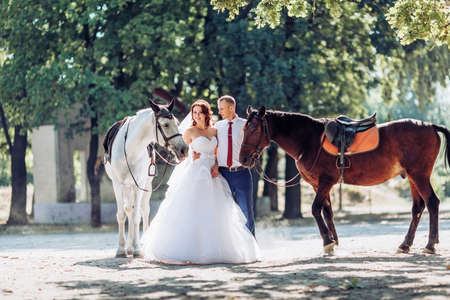 Bride and Groom at wedding Day walking Outdoors on spring nature. Bridal couple, Happy Newlywed woman and man embracing in green park. Loving wedding couple outdoor.の写真素材