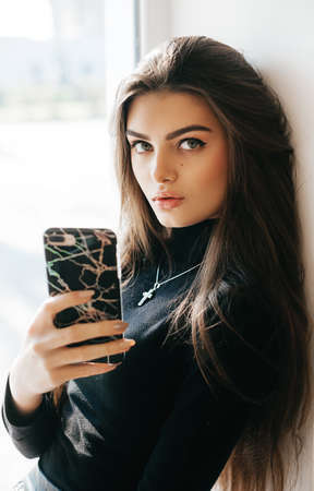 Portrait of beautiful young brunette with a mobile telephone