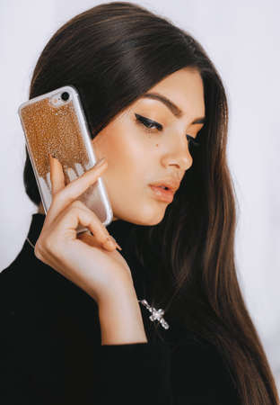 Portrait of beautiful young brunette with a mobile telephone
