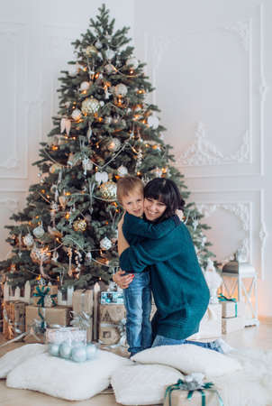 Happy boy with mather near Christmas treeの写真素材