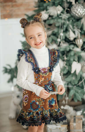 Beautiful baby girl near a Christmas tree with giftsの写真素材