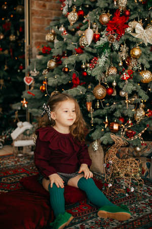 Beautiful baby girl near a Christmas treeの写真素材