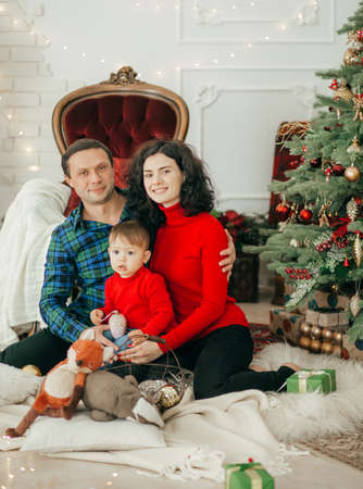 Happy boy with mather and father near christmas tree