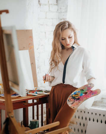 Portrait of beautiful young blonde woman with makeup in fashion clothes