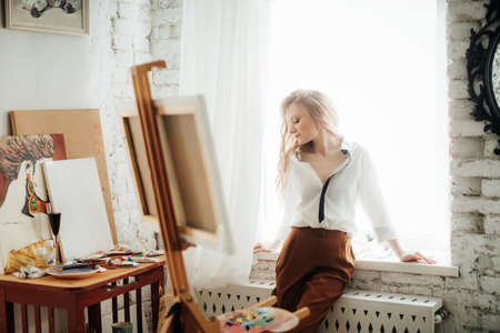 Portrait of beautiful young blonde woman with makeup in fashion clothesの写真素材