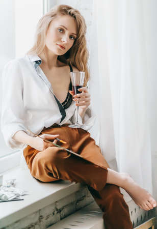 Portrait of beautiful young blonde woman with makeup in fashion clothesの写真素材