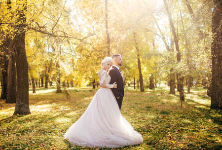 Happy bride and groom on their wedding in autumn gardenの写真素材