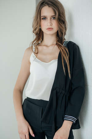 Portrait of a beautiful young girl with makeup in fashion clothesの写真素材