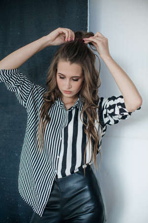 Portrait of a beautiful young girl with makeup in fashion clothesの写真素材