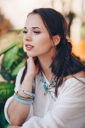 Portrait of beautiful young brunette woman with makeup in white dress