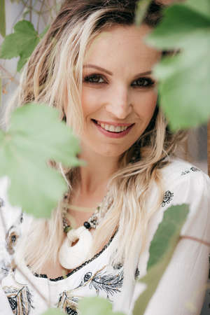Portrait of beautiful young blonde woman with makeup in white dressの写真素材