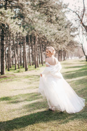 Beautiful blonde bride in white dress in the gardenの写真素材