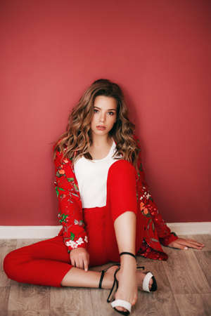 Portrait of beautiful girl with makeup in fashion red clothesの写真素材
