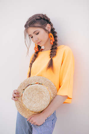 Portrait of beautiful girl with makeup with braids in hatの写真素材