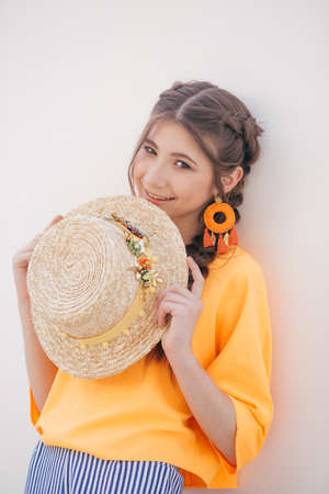 Portrait of beautiful girl with makeup with braids in hatの写真素材