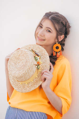Portrait of beautiful girl with makeup with braids in hatの写真素材