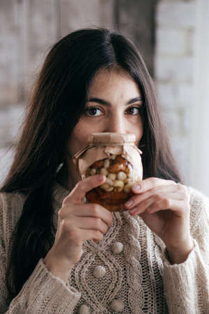 Stock Photo - Beautiful girl a girl with jars in which honey and nutsの写真素材