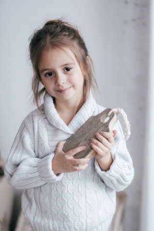 Stock Photo - Beautiful little girl with wooden christmas decor