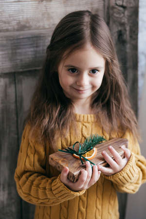 Stock Photo - Beautiful little girl with wooden christmas decorの写真素材