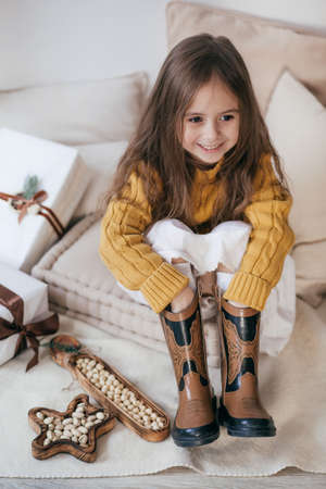 Stock Photo - Beautiful little girl with nuts on with wooden christmas decorの写真素材