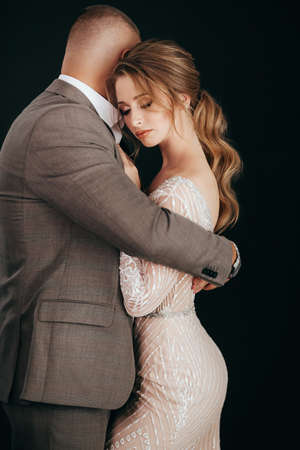 Stock Photo - Portrait of beautiful young wedding couple at black backgroundの写真素材