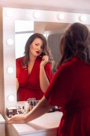Portrait of beautiful young woman with makeup in fashion red clothesの写真素材