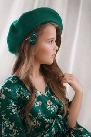 Portrait of beautiful brunette girl with makeup in green hatの写真素材