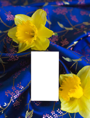 Luxury blue silk with white card and yellow flowers.の写真素材