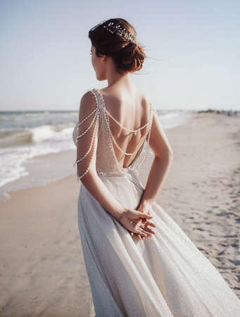 Beautiful brunette bride with stylish make-up in white dress in spring natureの写真素材